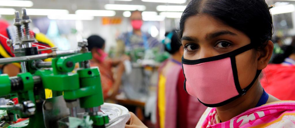 A Bangladeshi garment worker is seen wearing a face mask while producing clothing to be sold on major overseas markets. Photo: Marcel Crozet / ILO