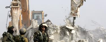 Israeli soldiers in front of bulldozers demolishing buildings. © EPA / Abed Al Hashlamoun