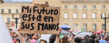 Protester at climate march holds up placard reading "Mi Futuro esta en sus manos" (My future is in your hands)