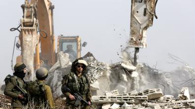 Israeli soldiers in front of bulldozers demolishing buildings. © EPA / Abed Al Hashlamoun