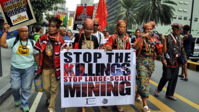 Kalikasan members march with signs saying "Mining plunder kills!" and "Stop the killings, stop large-scale mining". Photo: Kalikasan People's Network for the Environment.