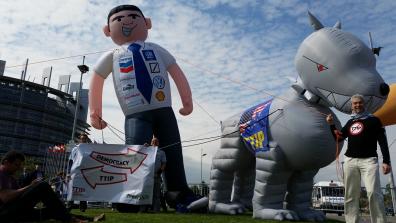 A TTIP protest in Strasbourg featuring giant inflatable figures of a 'corporate man' and his 'TTIP attack dog'.