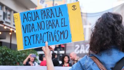 Women holding a protest sign against extractivism, Buenos Aires, August 2022